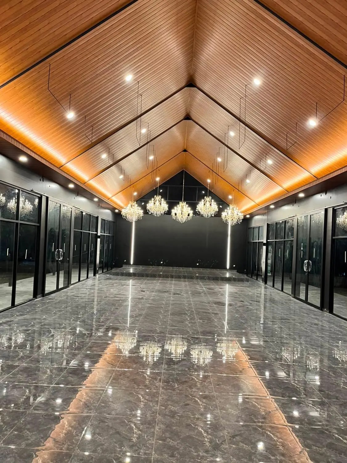 Interior glass house dengan plafon kayu dan chandelier